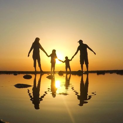 Silhouette of a family on a beach at sunset